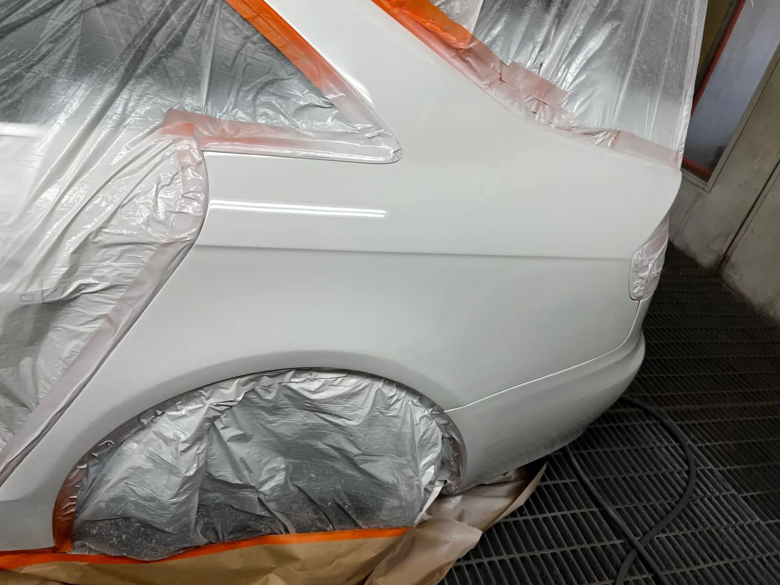 Silver rear quarter panel refinished with the wheel and glass masked